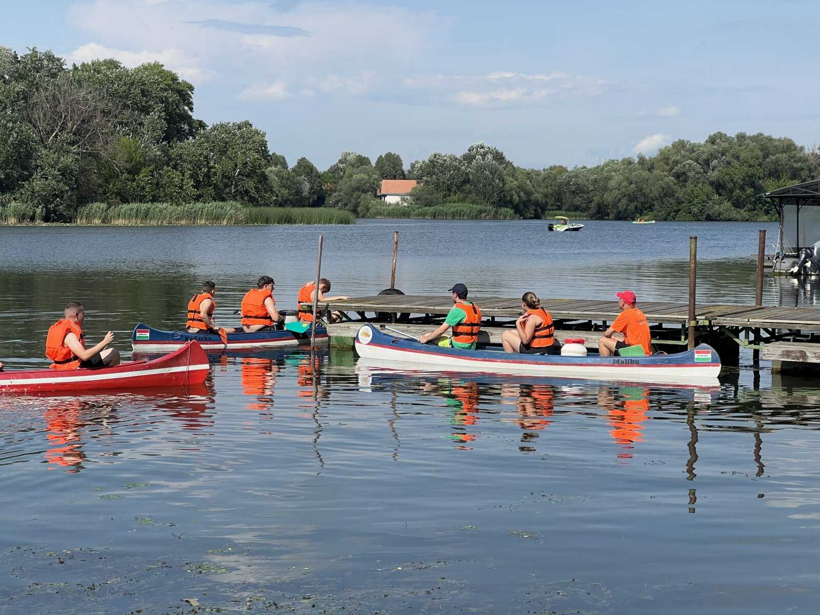 Mentőmellényes evezősök indulnak a stégtől a Tisza-tó vizére
