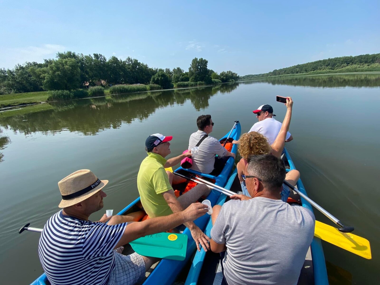 Kollégák jókedvűen eveznek egy kenuban a Tisza-tavon
